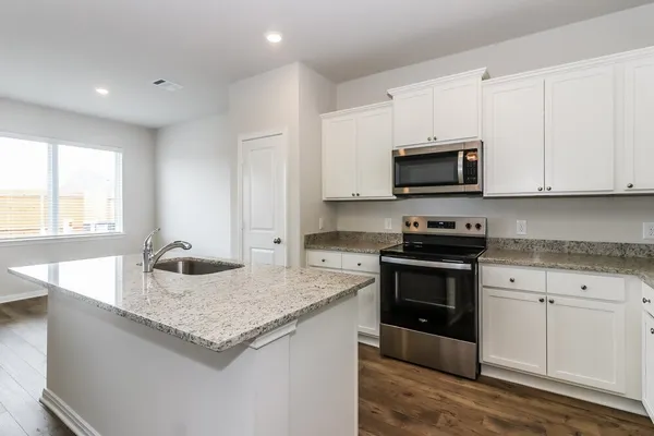 a kitchen with granite countertop a sink and steel appliances