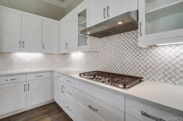 a kitchen with white cabinets and stove