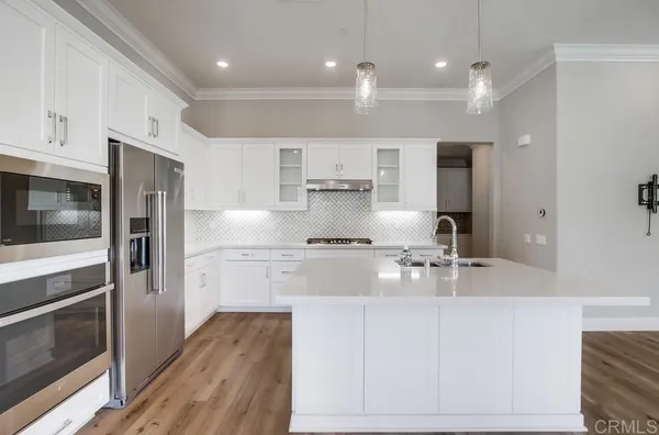 a large kitchen with stainless steel appliances kitchen island granite countertop a stove a sink and a refrigerator