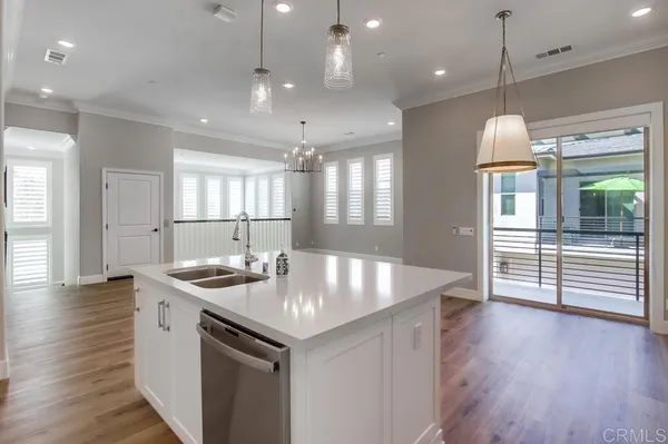 a kitchen with stainless steel appliances granite countertop a sink a stove and a wooden floor