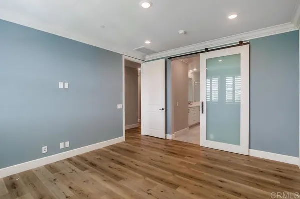 an empty room with wooden floor and entrance