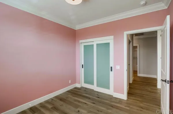 a view of an empty room with wooden floor