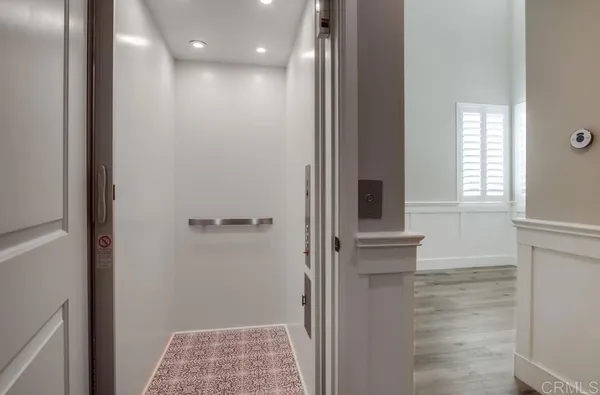 a view of hallway with window and wooden floor