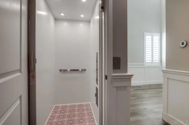 a view of hallway with window and wooden floor