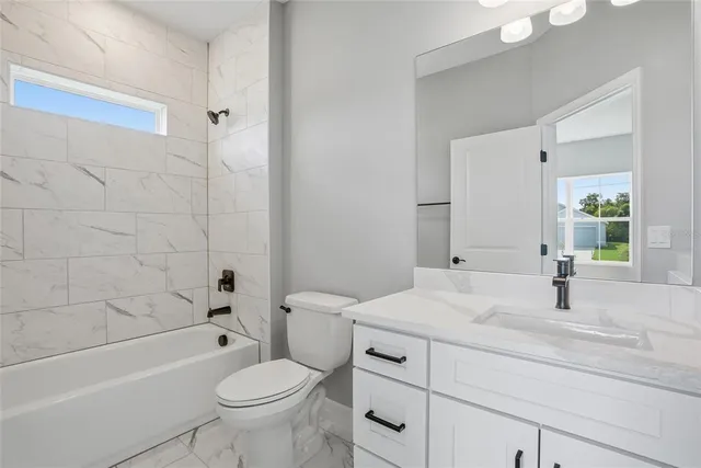 a bathroom with a sink toilet vanity and shower