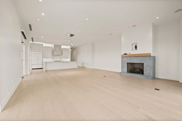 a view of a livingroom with a fireplace a ceiling fan and windows