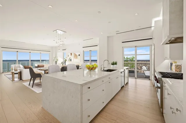 a large white kitchen with lots of counter top space and furniture
