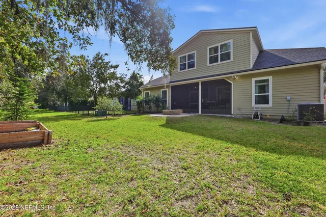 a front view of a house with garden and trees