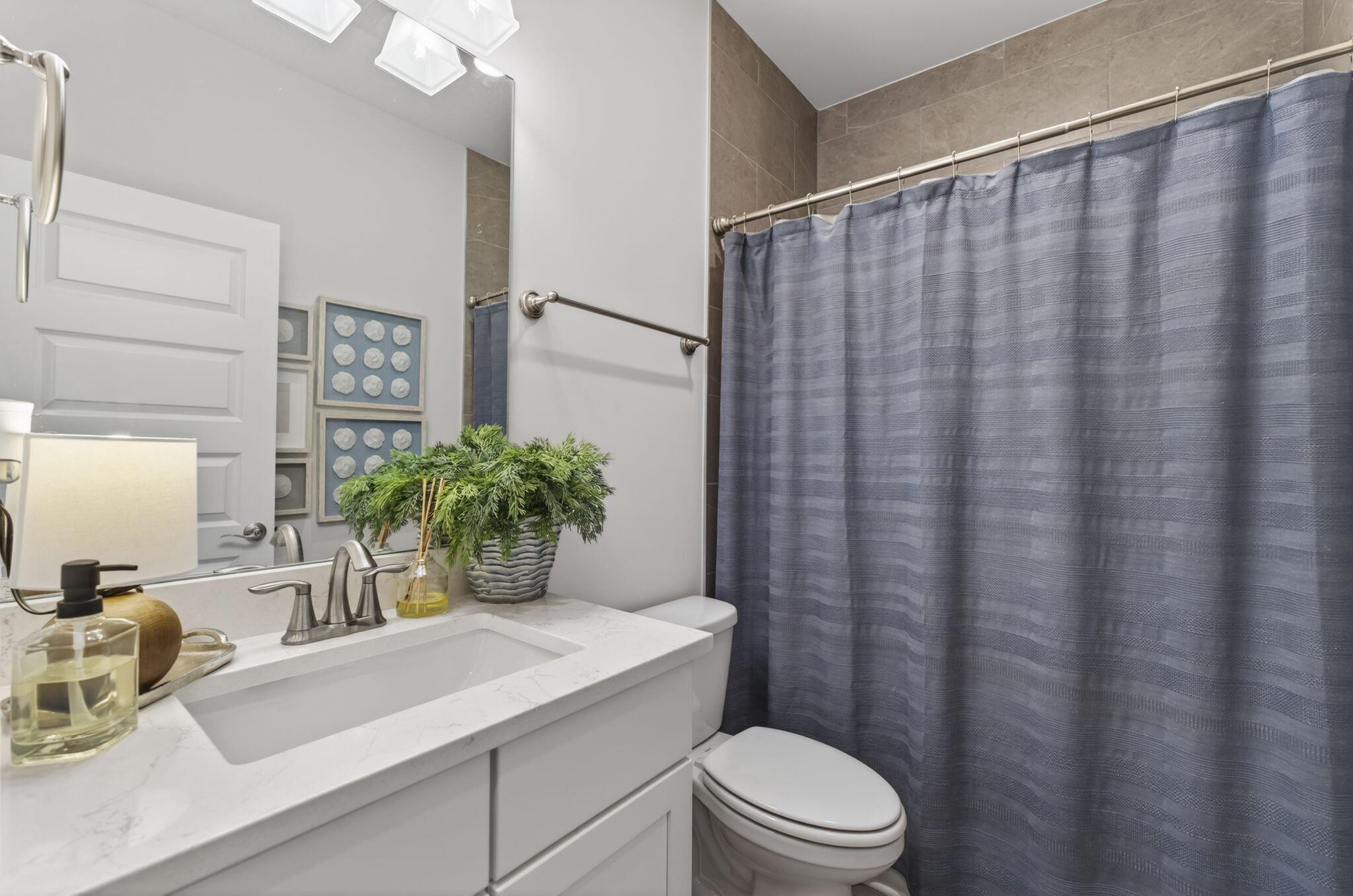 66 North J Hunters Way Freeport, FL 32439 - Photo 5 of 30 a bathroom with a sink a toilet and shower curtain