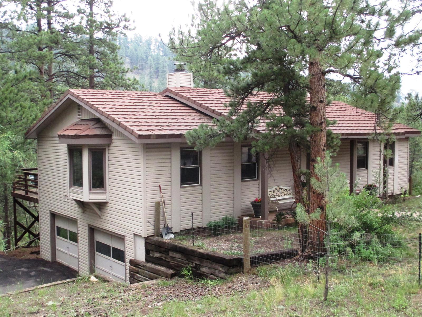 3164 South Piney Ridge Road Evergreen, CO 80439 - Photo 1 of 1 a front view of a house with a porch