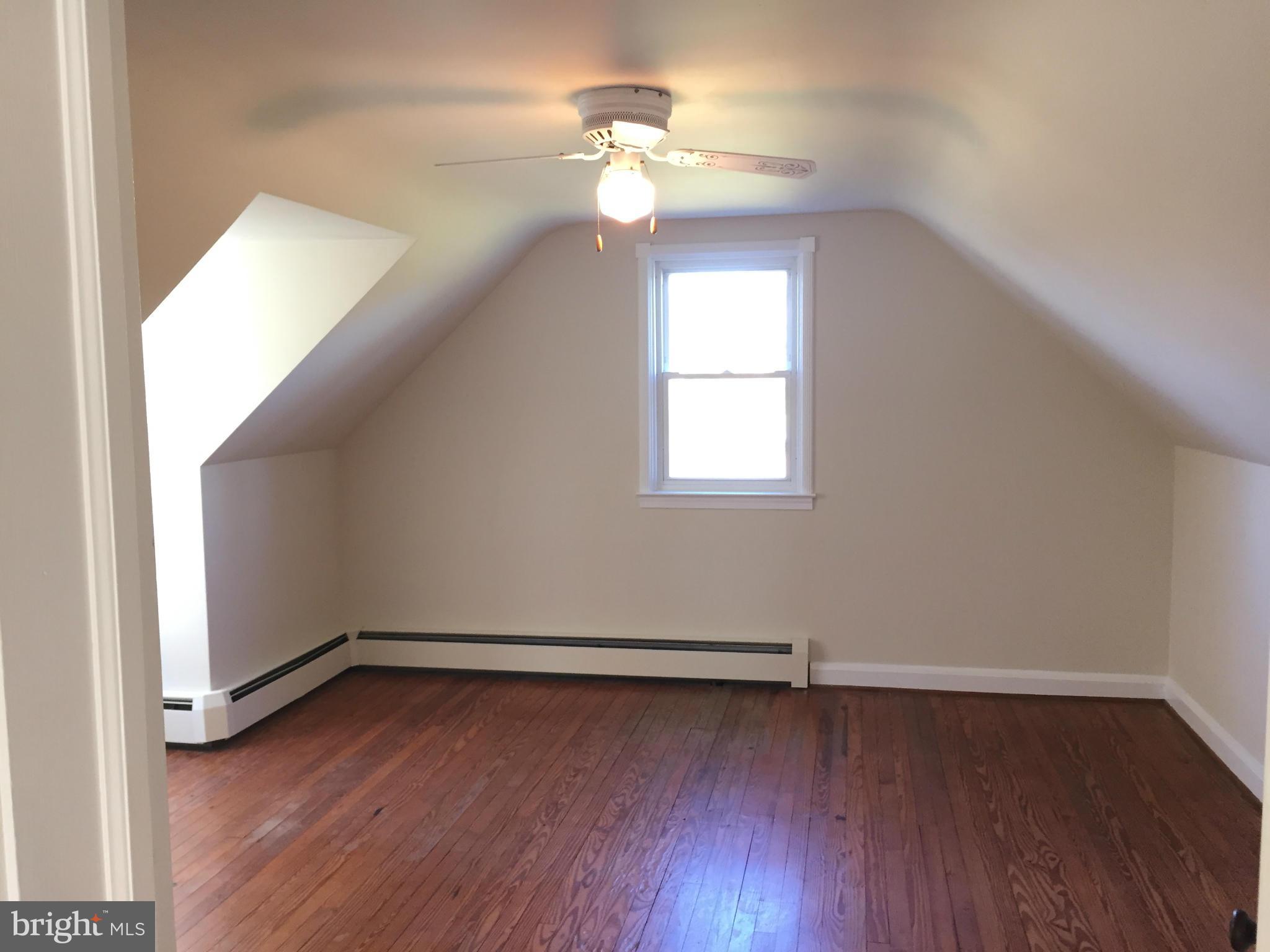 3025 Ridge Road Baltimore, MD 21244 - Photo 14 of 27 an empty room with wooden floor chandelier fan and windows