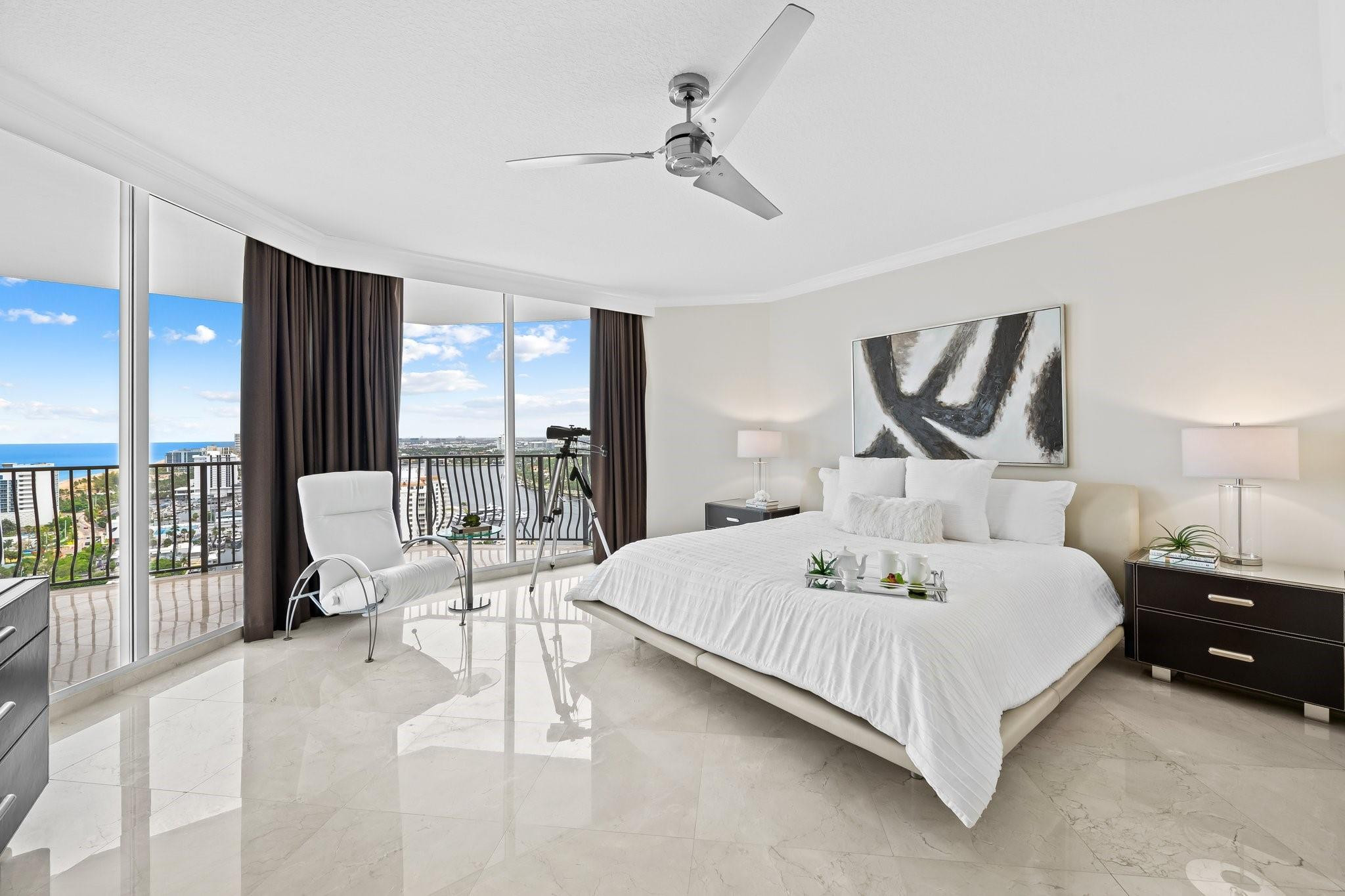 100 South Birch Road, Unit 2504 Fort Lauderdale, FL 33316 - Photo 18 of 42 a bedroom with a bed a chandelier and large window