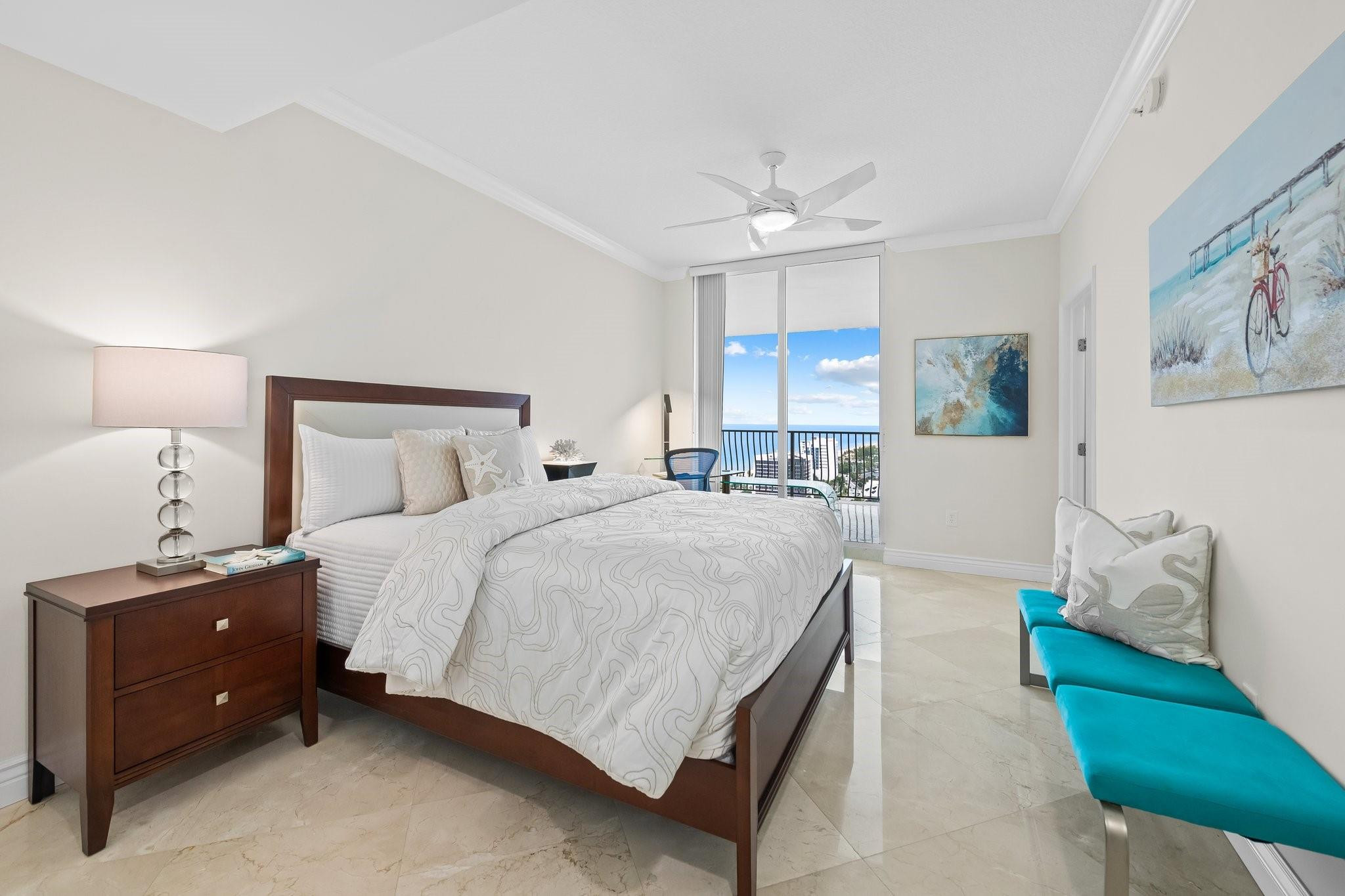 100 South Birch Road, Unit 2504 Fort Lauderdale, FL 33316 - Photo 23 of 42 a spacious bedroom with a bed and a chandelier