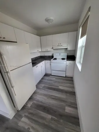 a kitchen with white cabinets and white appliances