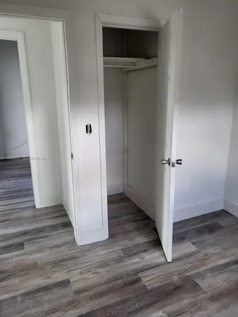 an empty room with wooden floor and closet