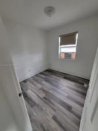 a view of a room with wooden floor and window