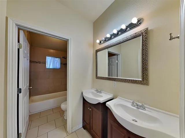 a bathroom with a sink a toilet a mirror and shower