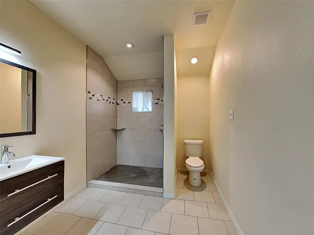 a bathroom with a double vanity sink toilet and shower