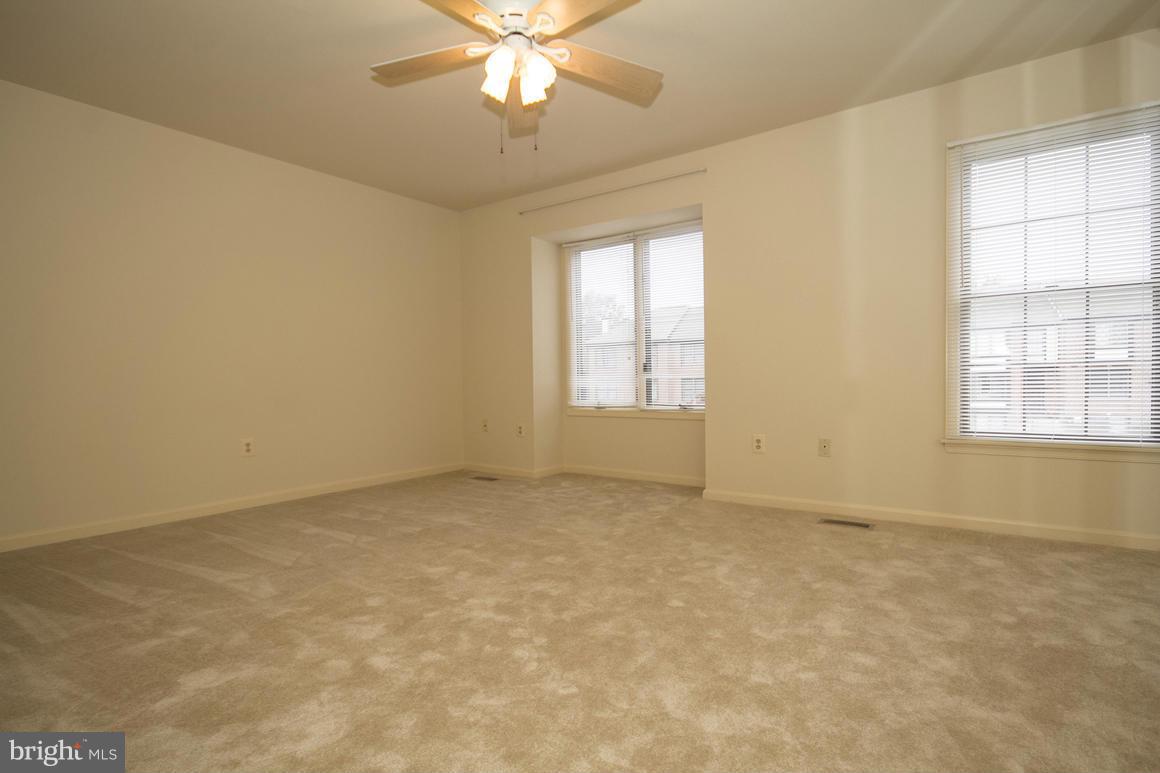 27 Rhodes Place Lutherville-Timonium, MD 21093 - Photo 12 of 19 an empty room with a chandelier fan and windows