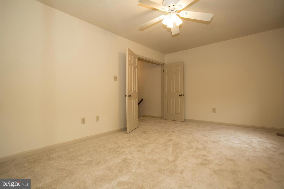 27 Rhodes Place Lutherville-Timonium, MD 21093 - Photo 10 of 19 an empty room with a chandelier fan and closet