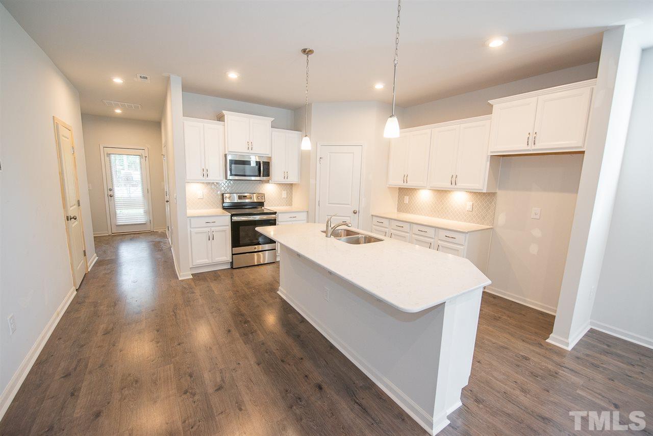 3620 Buffaloe Road, Unit 1 Raleigh, NC 27604 - Photo 6 of 25 a large kitchen with stainless steel appliances kitchen island a large counter top and wooden floors