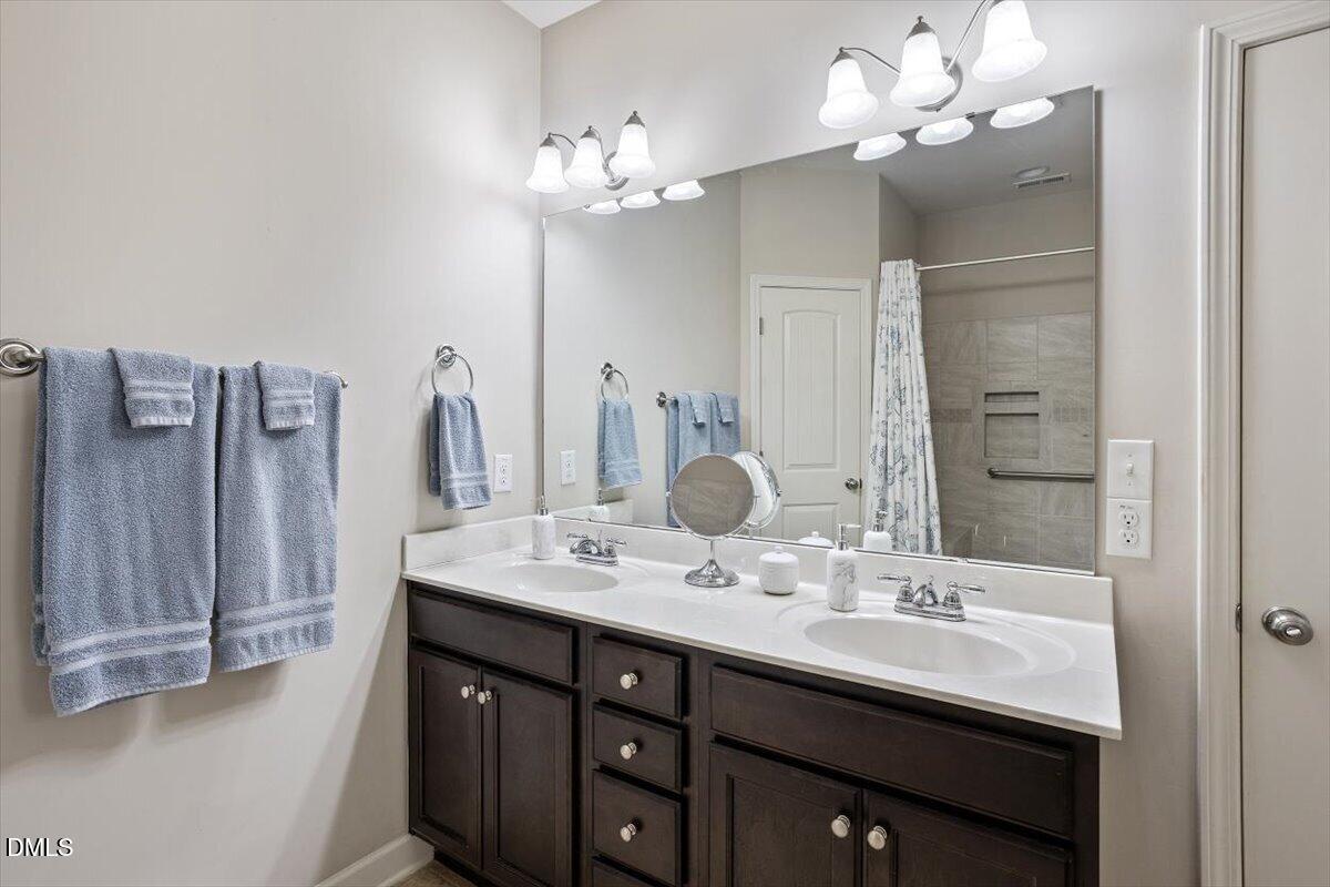 35 Fox Run Court Benson, NC 27504 - Photo 23 of 54 a bathroom with a double vanity sink a mirror and a shower