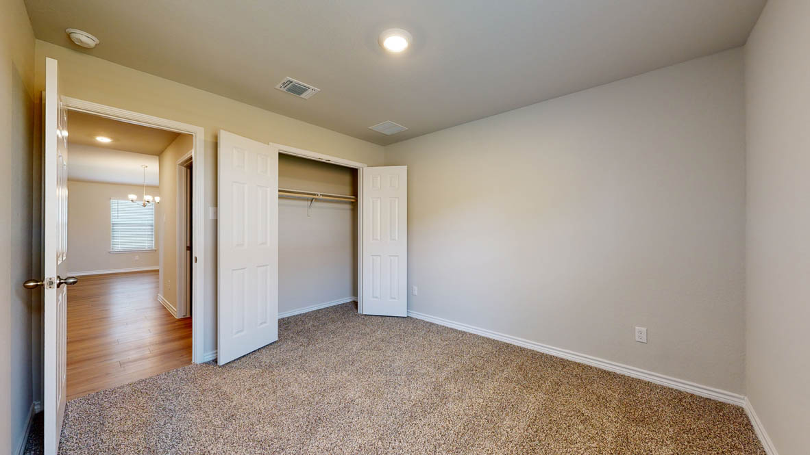 405 Creekfall Road Burnet, TX 78611 - Photo 17 of 27 an empty room with wooden floor and a bathroom