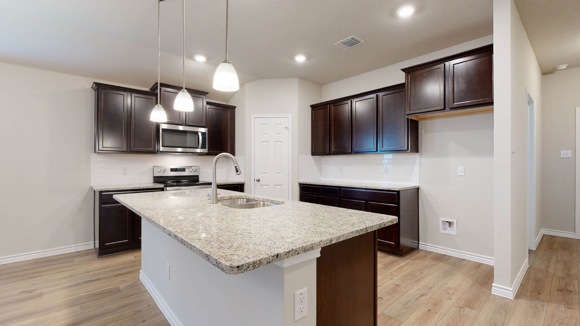 405 Creekfall Road Burnet, TX 78611 - Photo 7 of 27 a kitchen with granite countertop stainless steel appliances a sink cabinets and wooden floor