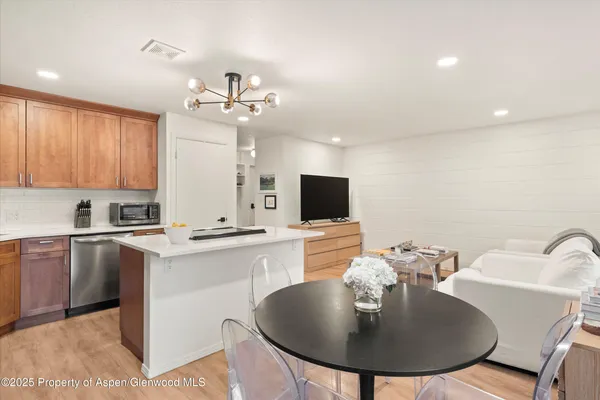 a kitchen with kitchen island a sink counter and chairs