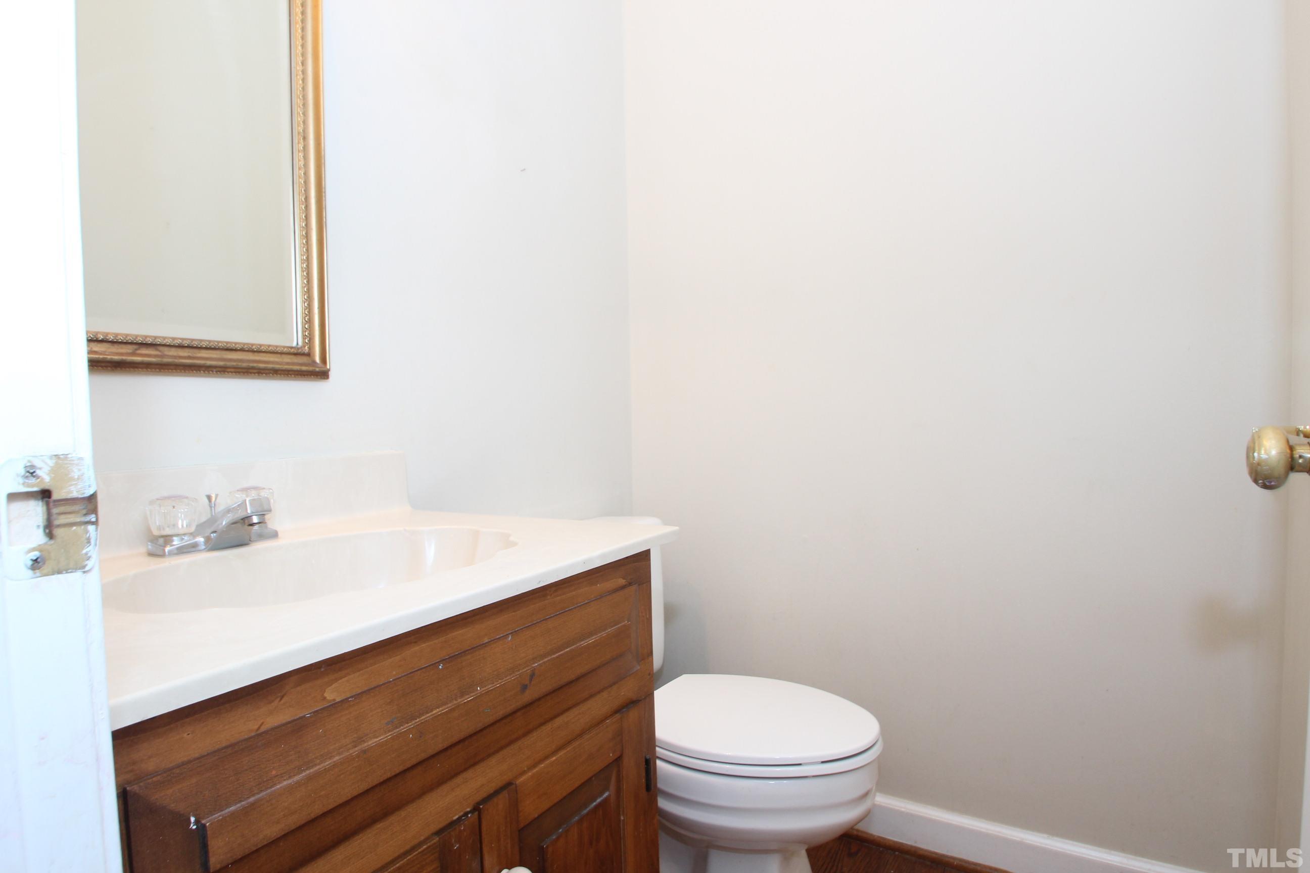 4013 Country Village Drive Raleigh, NC 27606 - Photo 11 of 23 a bathroom with a sink a toilet and a mirror