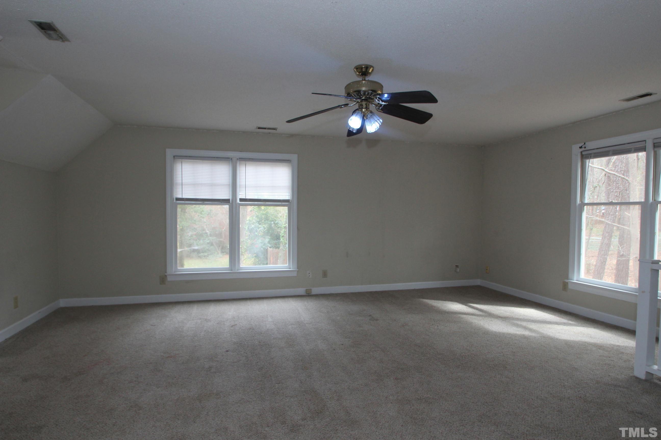 4013 Country Village Drive Raleigh, NC 27606 - Photo 13 of 23 an empty room with windows and chandelier fan