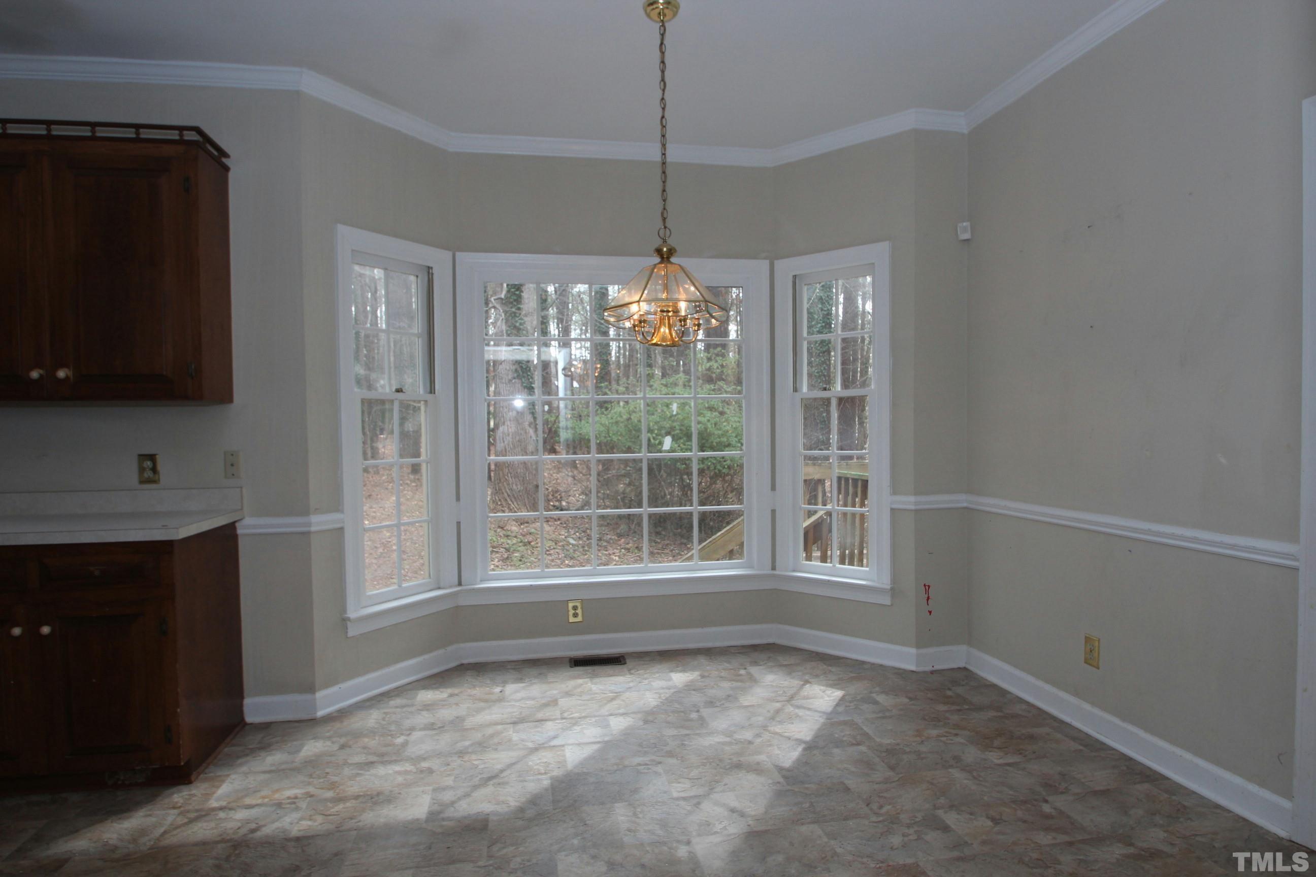 4013 Country Village Drive Raleigh, NC 27606 - Photo 7 of 23 a view of an empty room with window and cabinet area