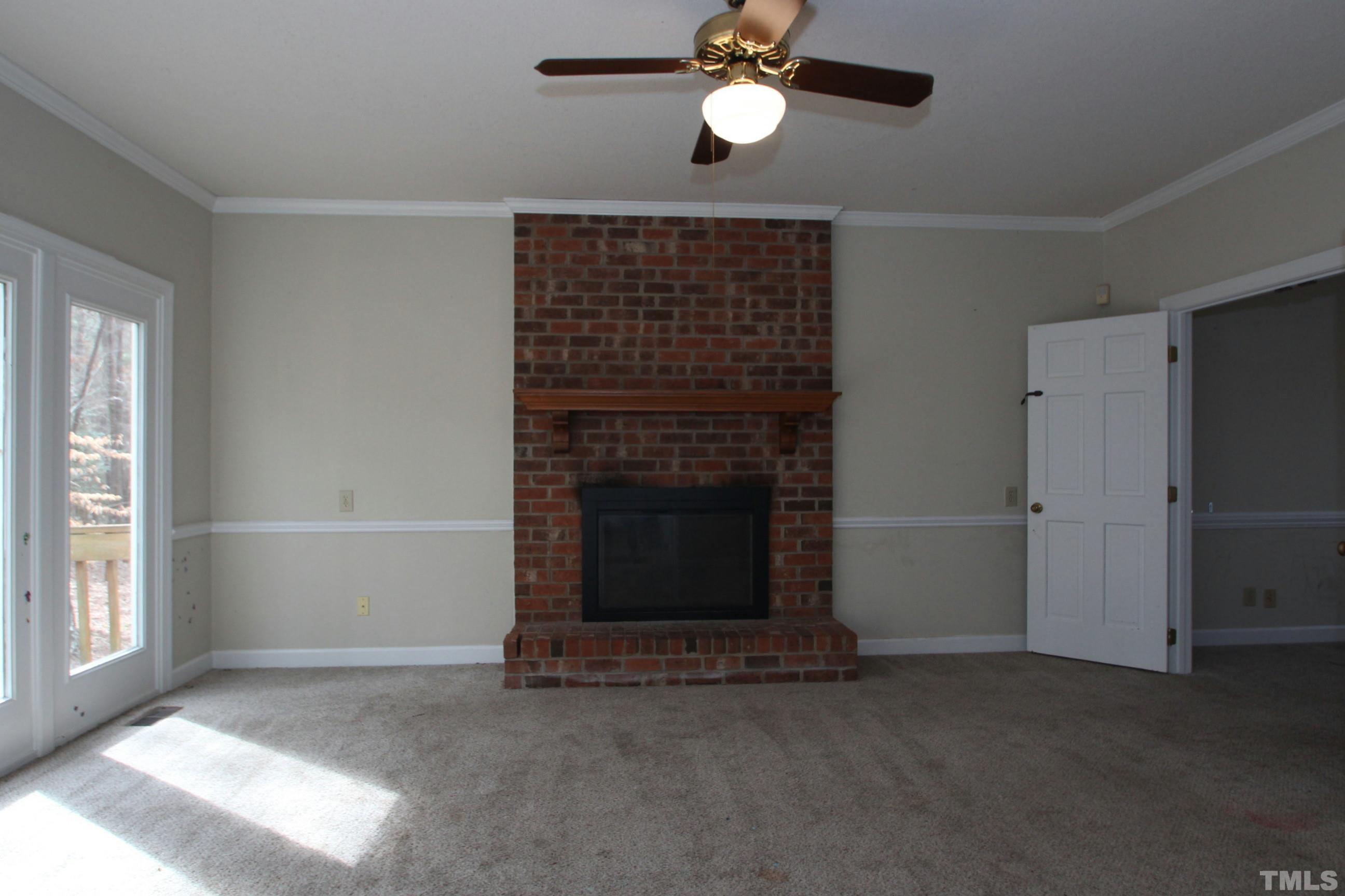 4013 Country Village Drive Raleigh, NC 27606 - Photo 8 of 23 an empty room with windows and fireplace