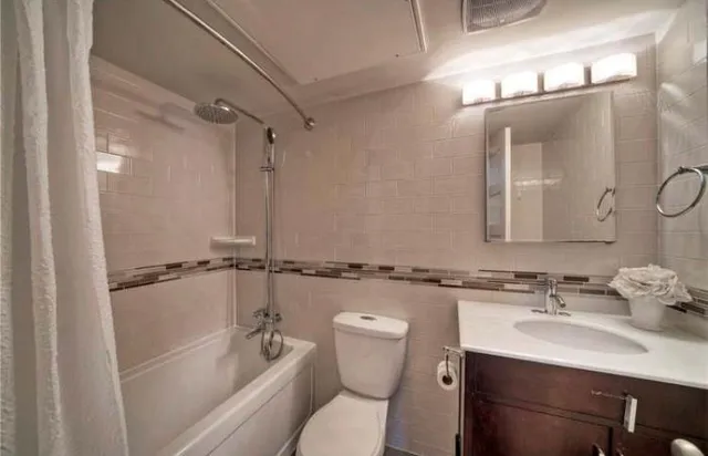 a bathroom with a sink a toilet a mirror and shower