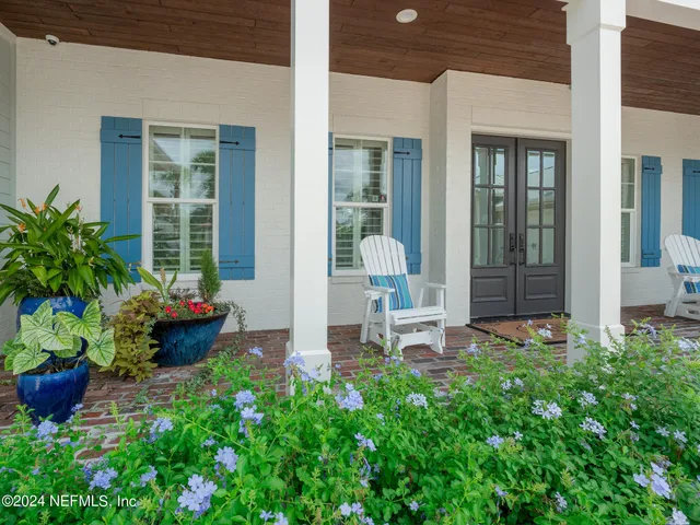 a garden with a bench in front of the house