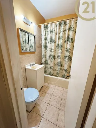 a bathroom with a sink a toilet a window and shower