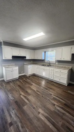 a large kitchen with stainless steel appliances wooden cabinets and a granite counter tops