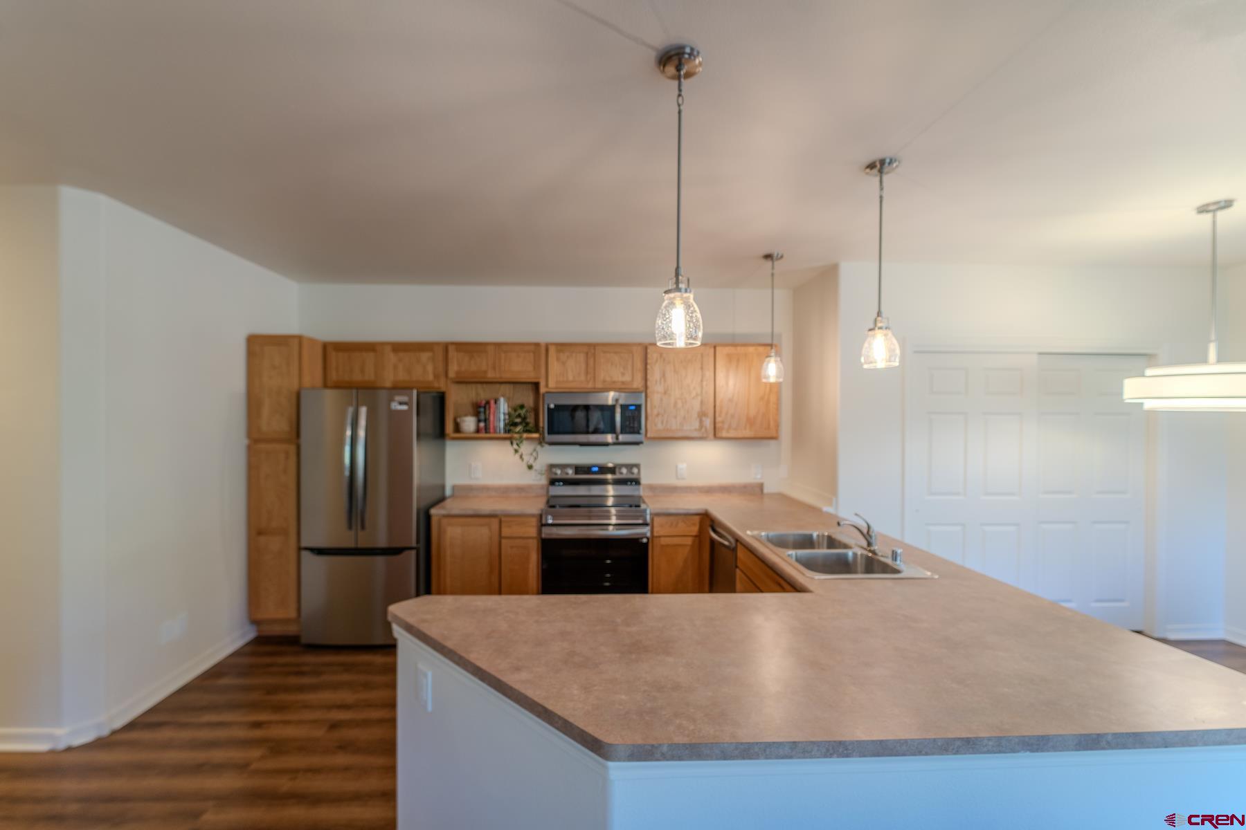 35 Sunshine Court, Unit 3 Durango, CO 81301 - Photo 18 of 26 a kitchen with stainless steel appliances granite countertop a refrigerator a sink a stove and a wooden floors