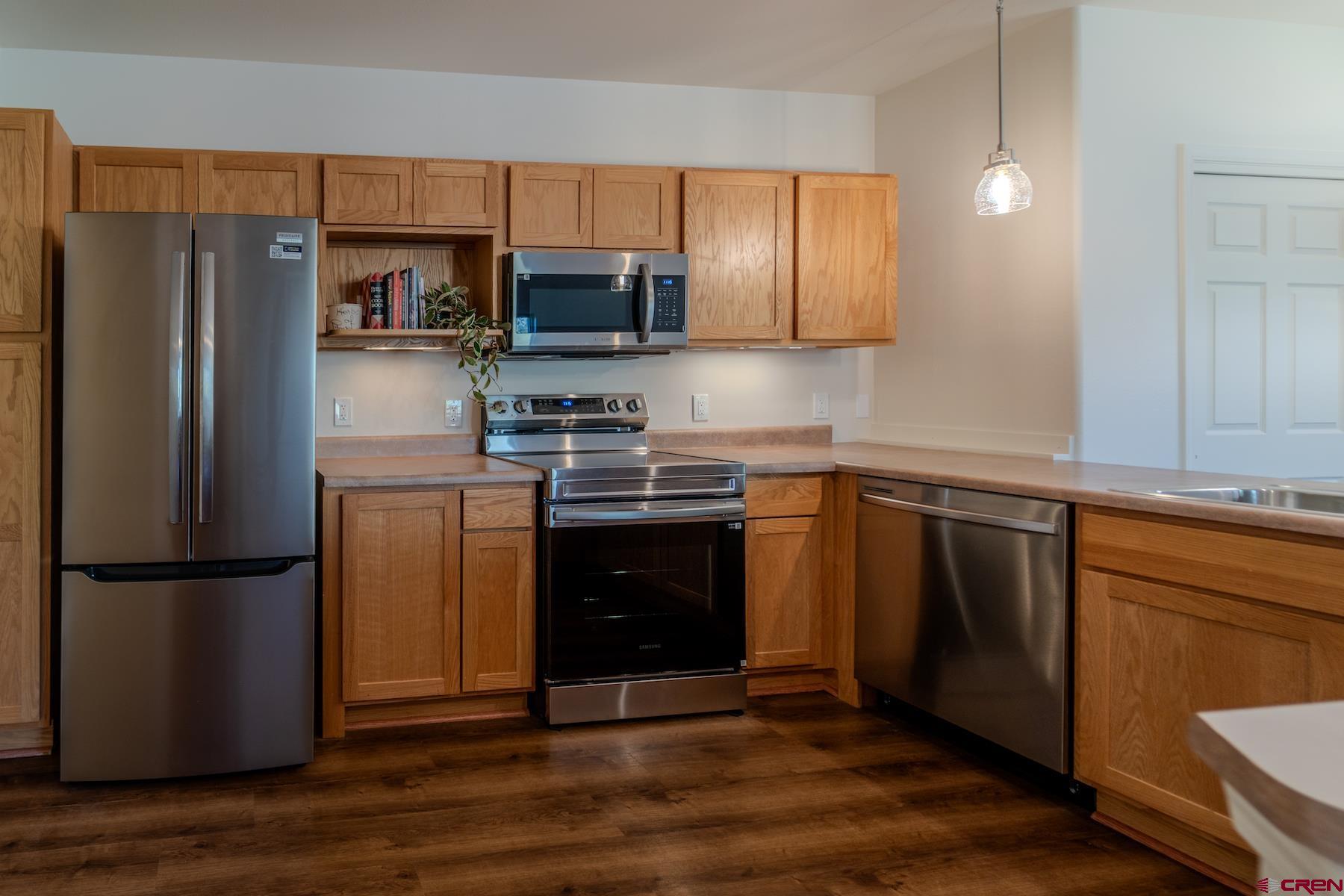 35 Sunshine Court, Unit 3 Durango, CO 81301 - Photo 5 of 26 a kitchen with stainless steel appliances granite countertop a refrigerator stove a sink and dishwasher with wooden floor