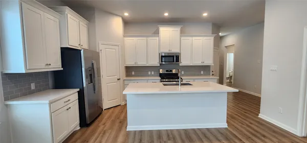 a kitchen with stainless steel appliances granite countertop a sink a refrigerator and a stove