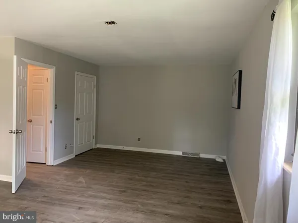 a view of small space with wooden floor and window