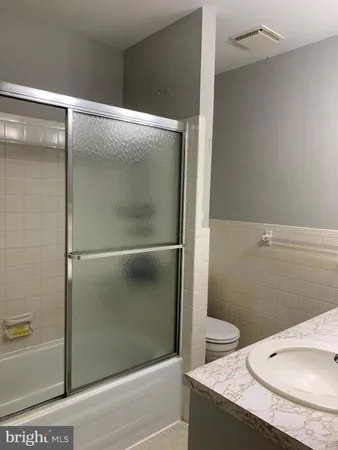 a bathroom with a granite countertop shower and a sink