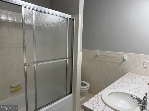 a bathroom with a granite countertop toilet and a sink
