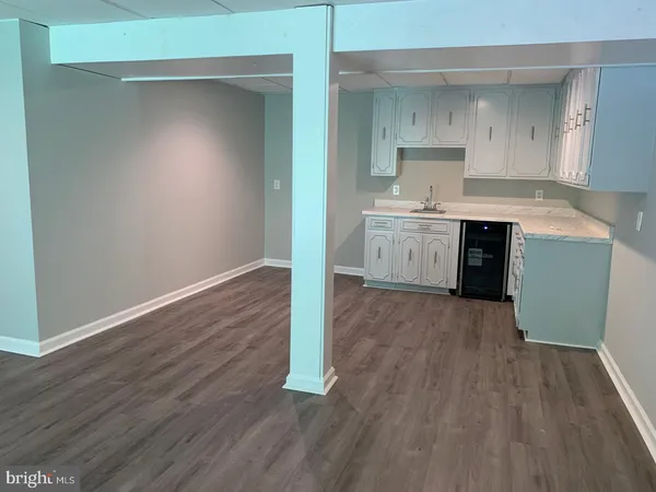 an empty room with wooden floor and cabinet