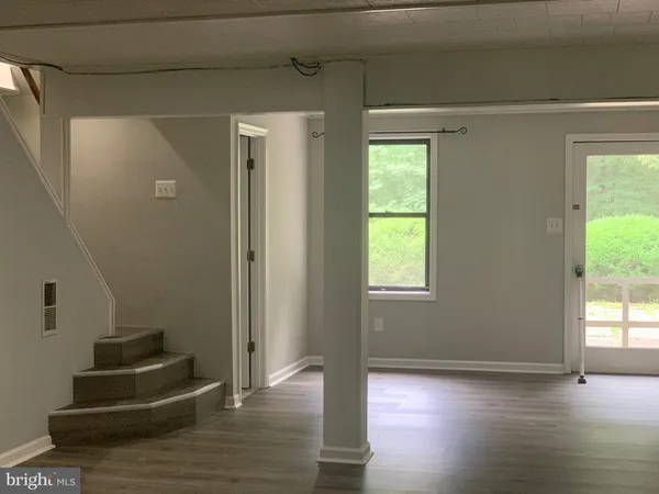 a view of a livingroom with wooden floor and a window