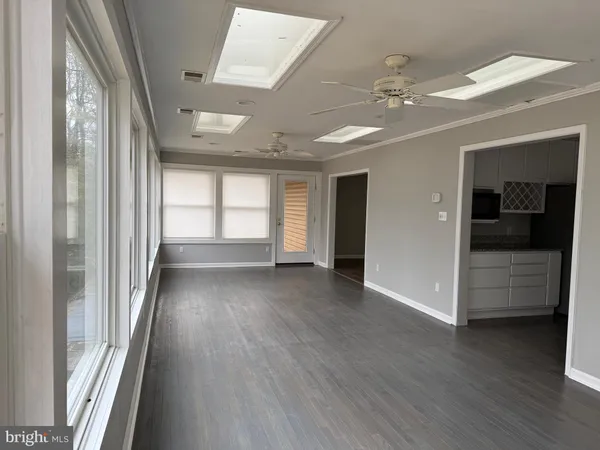 a view of a hallway with wooden floor and windows
