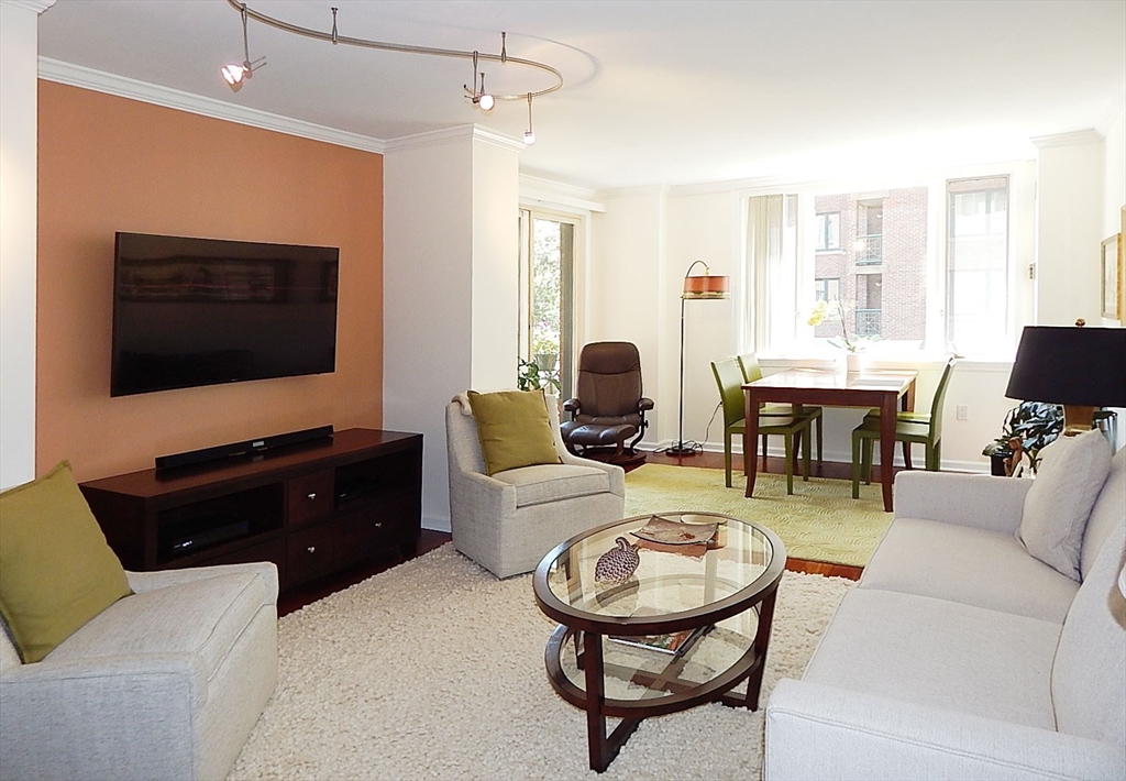 10 Rogers Street, Unit 203 Cambridge, MA 02142 - Photo 2 of 13 a living room with furniture a flat screen tv and kitchen view
