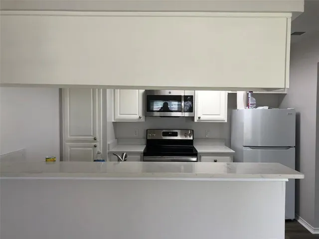 a kitchen with cabinets and stainless steel appliances
