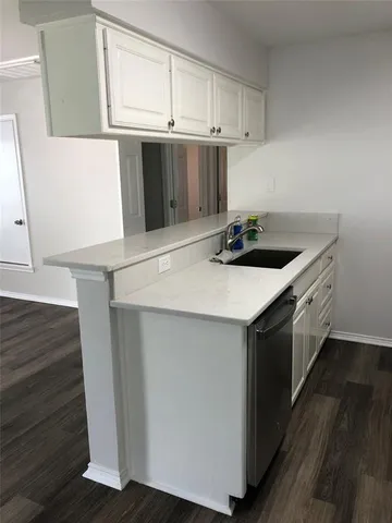 a kitchen with a sink cabinets and wooden floor