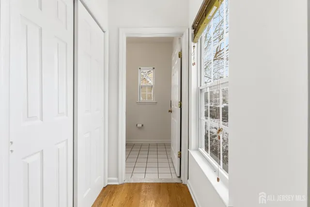 a bathroom with a toilet a sink a mirror and a window